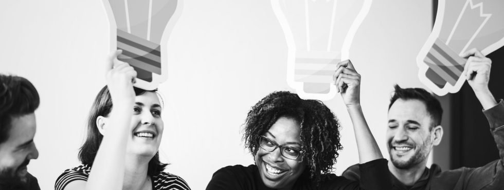 People Holding Up Light Bulb Icons